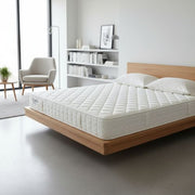 White mattress on a wooden bed frame in a modern bedroom.
